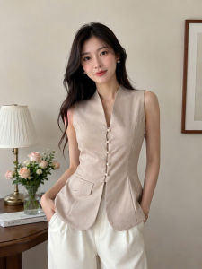 Áo vest không tay màu be với nút cài và túi nhỏ phù hợp với quần trắng trong không gian nội thất trang nhã.