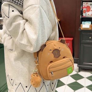 LANGJ จุได้มาก กระเป๋าไนลอน Capybara จี้ตุ๊กตาผ้าพลัฌ ป้องกันน้ำกระเซ็น กระเป๋าสะพายข้างที่สร้างสรรค์ สายรัดปรับได้ สีน้ำตาลสีน้ำตาลเข้ม กระเป๋าสะพายลายการ์ตูน สาวๆ