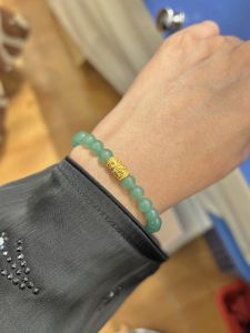 Put3Gold Colour beaded bracelet with gold charm on wrist.