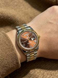 Exuding a retro charm that is both noble and avant-garde this 41mm quartz watch with dual date display features a two-tone gold case and a distinctive coffee-colored dial creating a striking contrast. It radiates a hint of aristocratic nostalgia capt