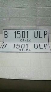 Plat nomor mobil warna dasar putih berlogo sepasang proses cepat dan rapih