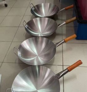 Goodshop Stainless steel wok with wooden handles four sizes non-stick surface suitable for stir-frying displayed on tiled floor.