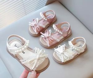 New 2026 collection of pink and white girls’ sandals with bow embellishments perfect for summer. Ideal for wearing at the beach with soft soles. A fashionable choice for girls. Princess-style non-slip sandals available in various sizes.