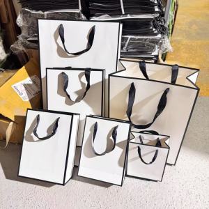 ถุงกระดาษ รุ่นสีขาว ขอบดำ หูหิ้วริบบิ้นหนา คุณภาพดี แนวตั้ง แนวสูง มีหลายขนาด ใส่สินค้า พร้อมส่ง