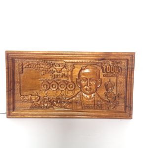 ไม้แกะสลักธนบัตรฉบับหนึ่งพันบาท ทําจากไม้สักแท้ ความกว้าง 15 cm. ความยาว 28 cm. มีขาตั้งสําหรับตั้งโต๊ะเหมาะแก่การบูชาและเป็นของขวัญล้ําค่า
