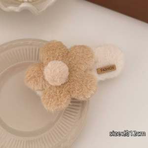 TERPE Fluffy Hair Clips flower-shaped hand warmers in pink beige and light blue with pom-pom centers.