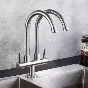 Stainless steel dual faucet with curved spouts and lever handles for kitchen sink.