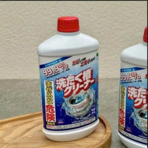 Dung dịch tẩy rửa 99.9% hiệu quả cao cho máy giặt chai nhựa trắng nắp đỏ thiết kế nhãn màu xanh dương và đỏ đặt trên khay gỗ.